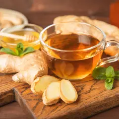 Kubek aromatycznej herbaty z imbirem, plasterkami cytryny i miodem. Zastanawiasz się, ile imbiru do herbaty dodać, by uzyskać idealny smak?