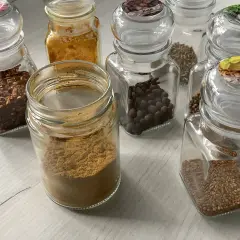 Słoiczki z przyprawami: płatki chili, kurkuma, kmin rzymski, kolendra, gorczyca i inne, idealne do przygotowania aromatycznego curry.